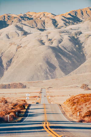 Highway at Big sur coast in California, United States of America. Mountains in background.