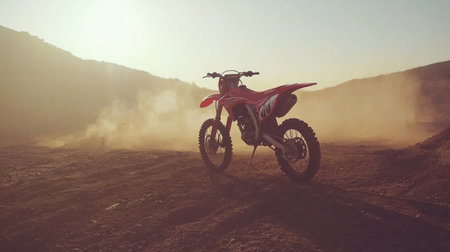 A dirt bike parked on a rugged motocross track, surrounded by kicked-up dust.の素材