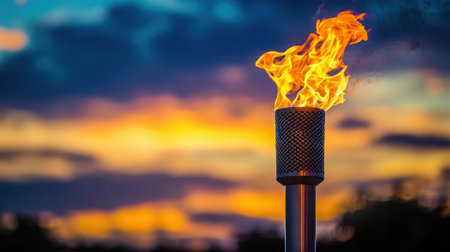 An Olympic torch burning brightly against a twilight sky.の素材