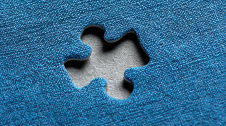 This image captures a close-up of a missing puzzle piece against a blue textured background, symbolizing the themes of completeness, curiosity, and problem-solving.の素材