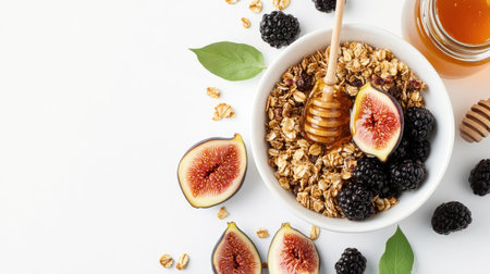 Top view of a bowl filled with granola, fresh figs, blackberries, and a honey jar on a white background, showcasing a wholesome meal.の素材