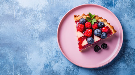 Slice of berry apple tart on a pink plate against a blue concrete background. Copy text space available for banners and advertisements.の素材