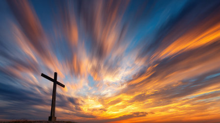 A striking sunset scene captures a cross silhouette against a vibrant sky, filled with dramatic clouds and rich colors, inspiring a sense of peace and reflection.の素材