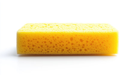 A bright yellow cleaning sponge isolated on a white background, ideal for household cleaning product advertisements or minimalist design concepts.の素材
