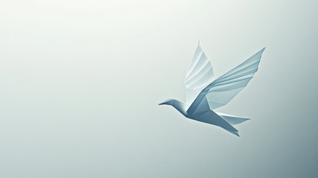A delicate origami paper bird appears to be in mid-flight, set against a clean white background. The crisp folds and soft colors of the paper create a serene and artistic imageの素材