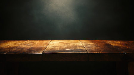 A wooden table in a dimly lit room, perfect for dramatic advertising or showcasing products with a touch of mystery and eleganceの素材
