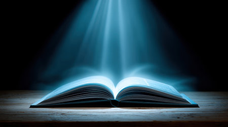 An enchanting open book radiates a bright light beam, creating a mystical atmosphere on a wooden table against a dark backdrop.の素材