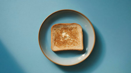 A single slice of golden brown toast rests on a simple plate, creating a bright and inviting scene perfect for breakfast or snack inspiration.の素材