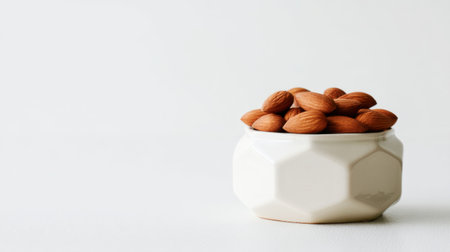 A beautifully styled bowl filled with fresh almonds presents a healthy snack option against a clean, minimalist backdrop, ideal for healthy eating.の素材