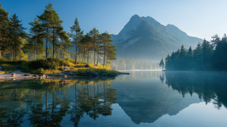 Discover the beauty of nature with this serene mountain landscape featuring a calm lake that reflects surrounding trees and blue sky.の素材