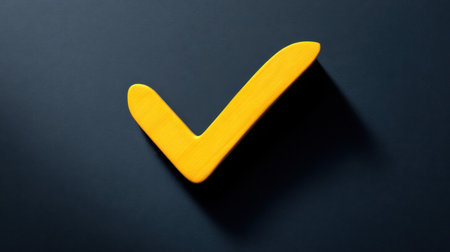This striking image features a yellow check mark symbol against a dark background, symbolizing approval and success in a minimalist style.の素材