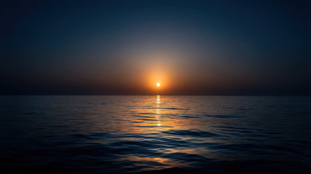A breathtaking view of a sunset over the calm ocean waters, showcasing golden light reflecting on the surface creating a tranquil scene.の素材