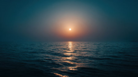 Experience the serene beauty of a calming ocean sunset with soft blue tones and golden reflections on water, capturing a peaceful evening mood.の素材
