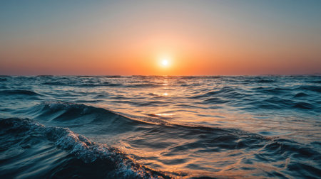 A breathtaking view of a sunset over the ocean, showcasing gentle waves and vibrant colors reflecting on the water. The scene evokes tranquility and beauty, perfect for relaxation.の素材