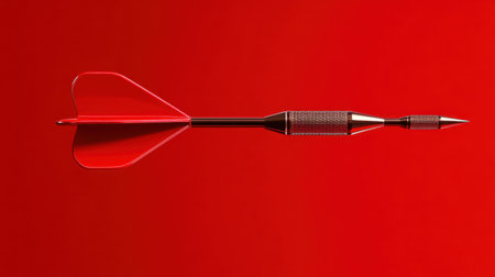 This stunning image features a sleek red dart arrow set against a vibrant red background, symbolizing precision and focus in sports and competition.の素材