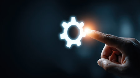 A human finger reaches towards a glowing gear symbol, showcasing the intersection of technology and creativity in modern innovations.の素材