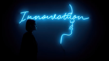 A woman stands in profile beside a bright neon sign that reads 'Innovation,' creating a striking contrast against a dark backdrop.の素材