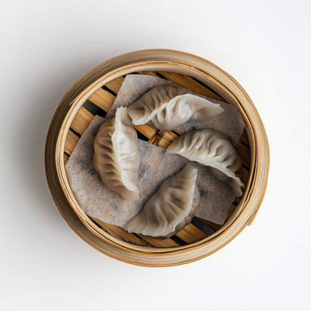 A collection of freshly steamed dumplings arranged in a bamboo basket, showcasing Asian culinary traditions. Perfect for food lovers and culinary presentations.の素材