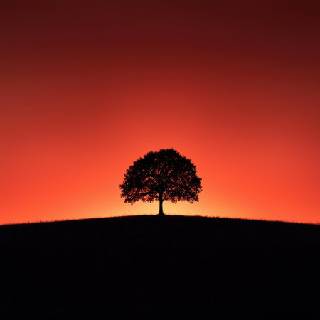 A solitary tree silhouette stands majestically against a vibrant sunset, showcasing nature's beauty in an atmospheric landscape. Ideal for backgrounds and serene themes.の素材