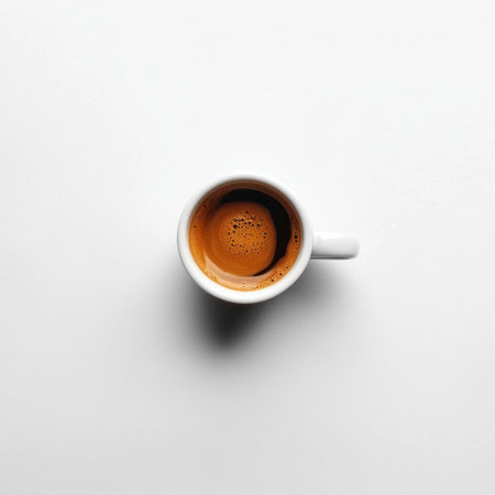 This image captures a minimalistic view of freshly brewed coffee in a white cup, showcasing rich creamy foam and inviting aroma, perfect for coffee enthusiasts.の素材