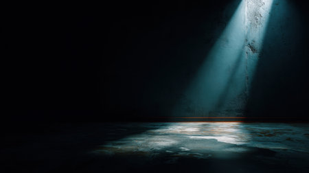 A stunning visual featuring a single beam of light illuminating a dark, grungy room with a textured wall and concrete floor, creating a dramatic atmosphere.の素材