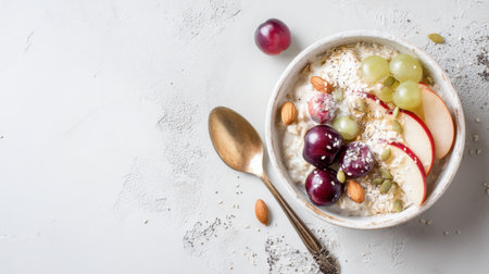 A vibrant and healthy breakfast bowl filled with yogurt, granola, fresh fruits like apples and grapes, topped with nuts and seeds, perfect for any meal.の素材