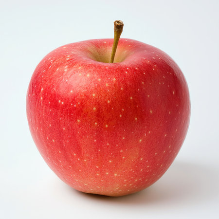 Close-up of a fresh red apple showcasing its vibrant color and smooth texture. Ideal for themes around health, nutrition, and natural foods.の素材