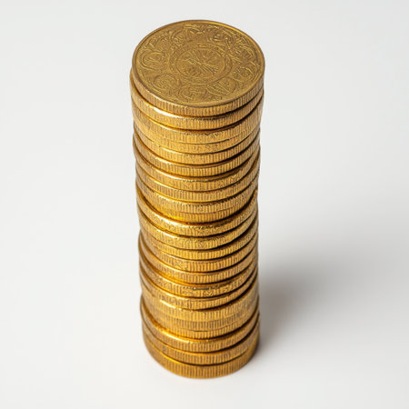 A tall stack of shiny gold coins stands prominently on a plain background, symbolizing wealth and financial success. Ideal for financial themes.の素材