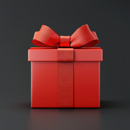 A vibrant red gift box adorned with an elegant ribbon and bow, perfect for festive celebrations and special occasions, set against a dark background.の素材