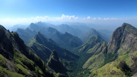 A breathtaking view of a majestic mountain range surrounded by lush green valleys and under a clear blue sky, showcasing the beauty of nature.の素材