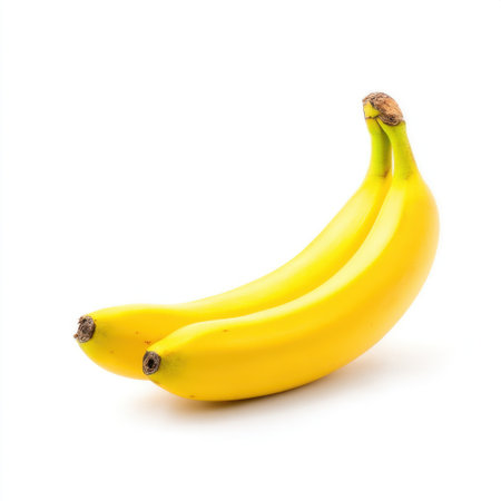 A pair of fresh yellow bananas is shown against a clean white background, symbolizing health, vitality, and deliciousness perfect for various culinary uses.の素材
