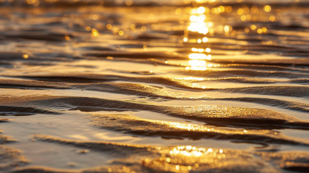 A mesmerizing view of a water surface at sunset showcasing golden hues and gentle waves. The sunlight creates a stunning reflective effect, enhancing the peaceful beauty of a serene evening.の素材