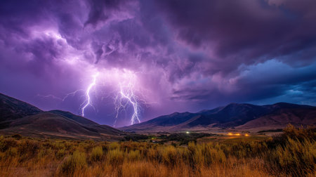 A stunning view of a thunderstorm above a mountain landscape at dusk, featuring striking lightning illuminating the dramatic sky.の素材