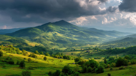 Scenic mountain landscape showcases rolling hills and lush greenery under a dramatic sky filled with clouds. A tranquil atmosphere invites exploration and appreciation of nature's beauty.の素材