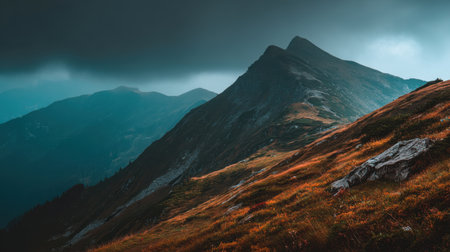 This stunning mountain landscape showcases a dramatic scene with dark clouds hovering above vibrant autumn foliage, creating a serene wilderness atmosphere.の素材