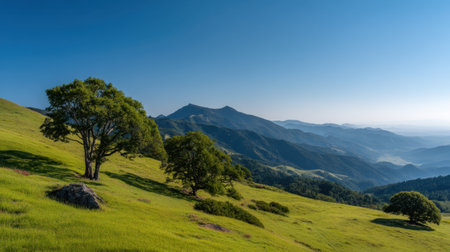 Discover a stunning landscape showcasing lush green hills, vibrant trees, and distant mountains under a clear blue sky. Perfect for nature lovers.の素材