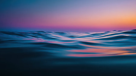This captivating image showcases the serene ocean waves under a colorful sunset sky. The gentle ripples reflect vibrant hues, creating a soothing atmosphere.の素材