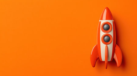This vibrant image features a classic retro rocket toy in bold orange and white colors, ideal for themes of imagination and creativity.の素材