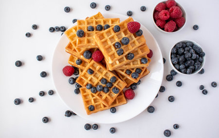 Traditional Belgian waffles with blueberries and raspberries for breakfast
