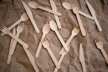 Wooden forks and knives on Kraft. Eco-friendly disposable tableware. Used in fast-food, restaurants, take-away, picnics. Plastic-free Zero waste. top view.の写真素材