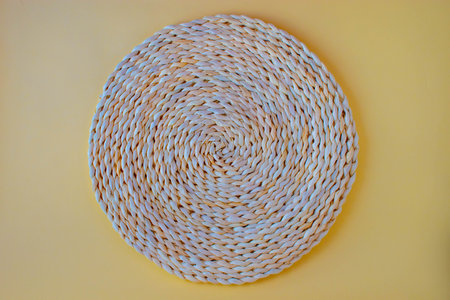 Wicker straw stand isolated on a sandy background. Flat, top view minimal template for social media