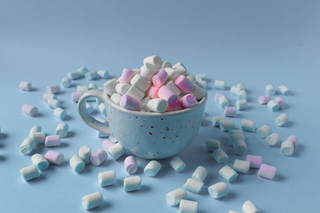 Marshmallows. Chewy sweets close-up on a pink background. Sweet food dessert pouring out of a white...