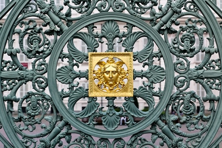 A golden mask in the center of an artful fence in Torino, Italyの写真素材