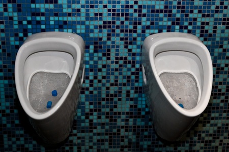 Two pissoirs on a mosaic wall in a public space in Vienna