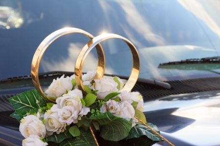 A flower arrangement with big golden rings for a wedding on a black carの写真素材