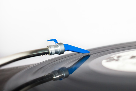 Closeup of a DJ needle on black vinyl record on a classic turntableの写真素材