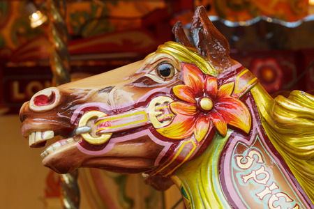A shiny wooden head of a horse on a vintage carouselの写真素材