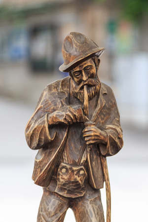 Carved wooden figure of an old full bearded resident from the alps lighting a pipeの写真素材