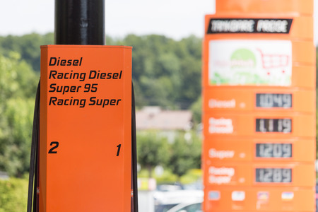 A detail of a gas station with different fuel types and the price board in the backの写真素材