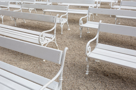 White classic wooden park benches on gravelの写真素材